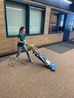 Student vacuuming the atrium.
