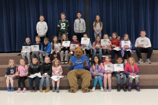 Students pose with Grizz, the school mascot, as this month's award recipients.