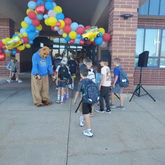 Grizz welcomes kids to school.